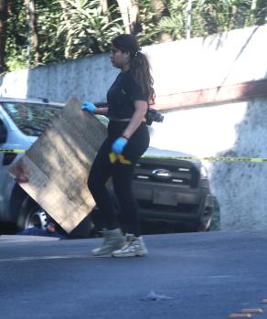 Perita sostiene el mensaje que los criminales dejaron ayer en el lugar donde dejaron una bolsa con restos humanos.