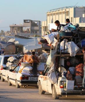 Con las pocas pertenencias que tienen, decenas de desplazados evacuan la zona de Rafah, ayer.