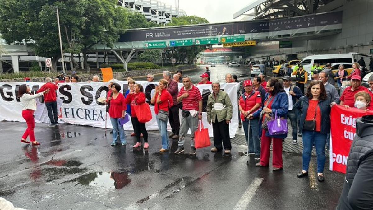 Manifestantes defraudados de Ficrea paralizan acceso a Terminal 1 del AICM