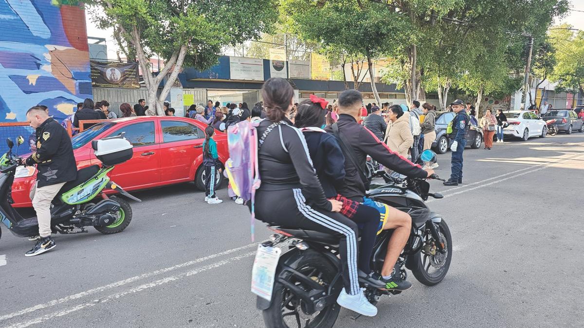 En la motocicleta y sin casco, llevan a sus hijos a la escuela